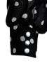 The blouse is cut in a loose fit from a black silk with white polka-dots. It has blouson sleeves with buttoned cuffs.
