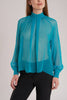 This turquoise blouse is a testament to GINTA's eye for vibrant colors and exquisite fabrics.