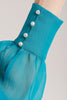This turquoise blouse is cut from pure silk georgette and has pearl button fastening at neck and cuffs.