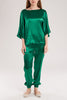 The emerald green silk satin trousers are elasticated at the waist and ankles for a relaxed fit.