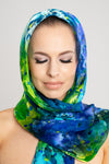The scarf in green and blue silk is expertly hand-crafted from a colourful silk satin.