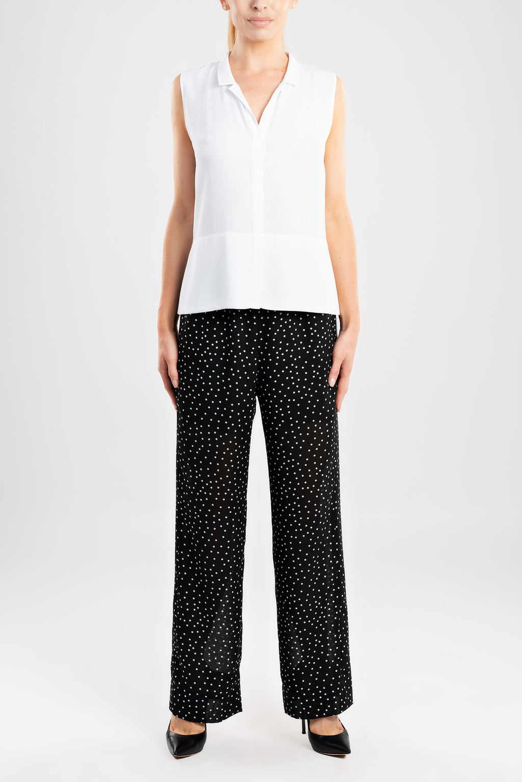 The wide-leg pants are tailored from a luxurious black fabric with white polka-dots. 