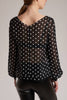 GINTA's white polka-dots blouse has an elegant boat neck at the front and a V cut at the back.