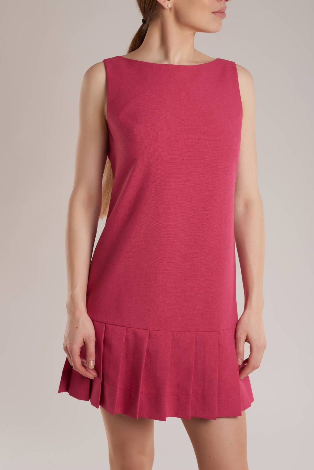 A mini fuchsia dress has an A-line shape with a boat neck, a pleated hem and a concealed zip fastening at back. 