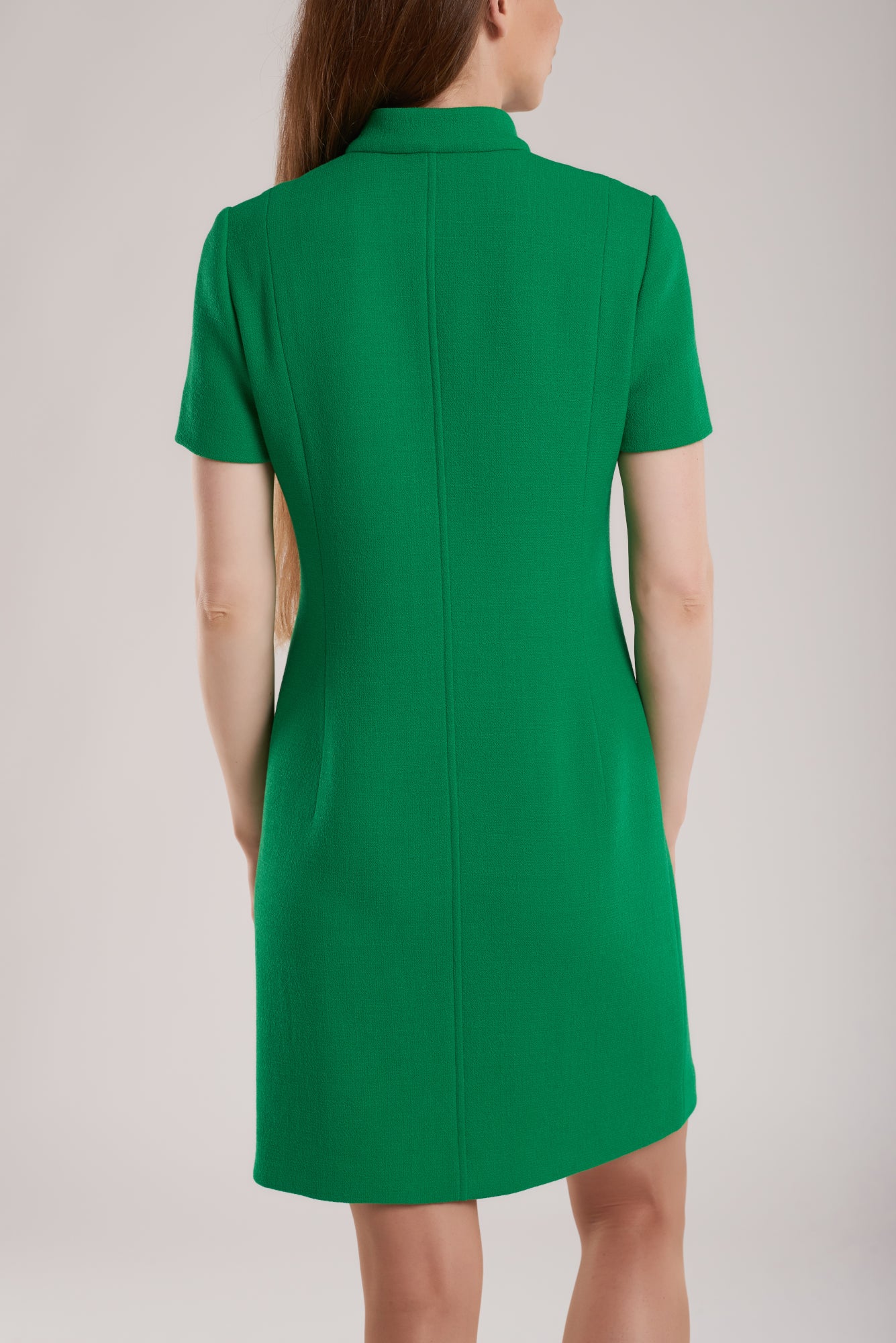 Tailored from green wool boucle, this coat dress has clean lines that beautifully highlight the figure.