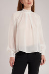 GINTA has an eye for soft pastel colors and exquisite fabrics, and this ivory silk blouse is a testament to that. 